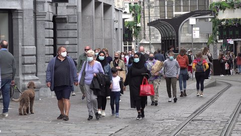 GHENT, BELGIUM – AUGUST 2020: Crowds of people wear compulsory face masks in downtown Ghent shopping street, Covid-19 coronavirus in Belgium
