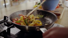 Close-up of woman's hand cooking food in frying pan over the gas stove - Powered by Shutterstock - Get 15% off with code: PIKWIZARD15