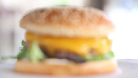 camera focuses on hamburger with cheese close-up