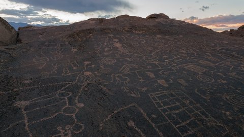 Time lapse tracking shot of sunset sky over Native American rock art panel in California
