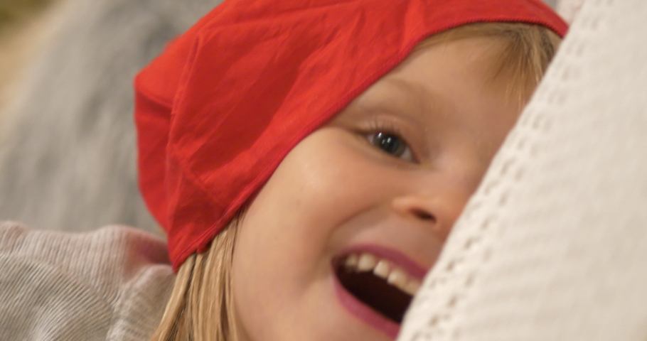 Joyful young little Girl with red hat smiling happily, Close up