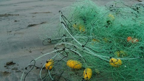 plastic contamination of the ocean, fishing net on the beach. fishing net lying on the shore. fishing industry