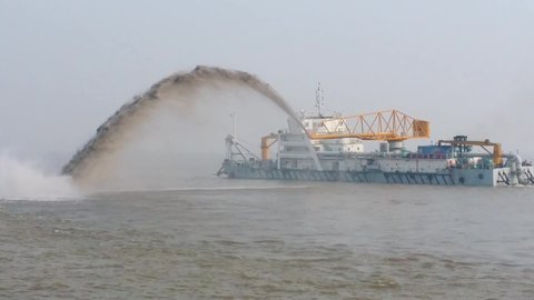 Dredging Vessel in action to keep waterways navigable, excavate and gathering sediments in the bottom and disposing at another location, Shanghai river, China