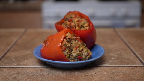 Stuffed sweet bell peppers on a plate and ready for that first mouthwatering bite - slow dolly forward