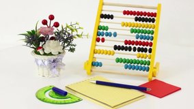 Different office supplies notepad and consumables on white rolling table background.