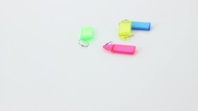 Different office supplies keychains and consumables on white rolling table background.