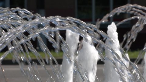 Water jets from the fountain. Water jet. City fountain. Water pressure. How to survive the heat. Hot summer in the city. Fountain splashes close up. Dancing fountains. Splashes shining in the sun.
