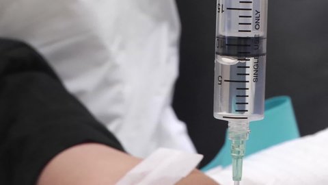 Syringe to IV in Patient's Arm Rack Focus