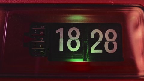 Retro old vintage flip clock with orange body and green or teal light. Getting late, time to sleep. Timelapse with dolly zoom effect.