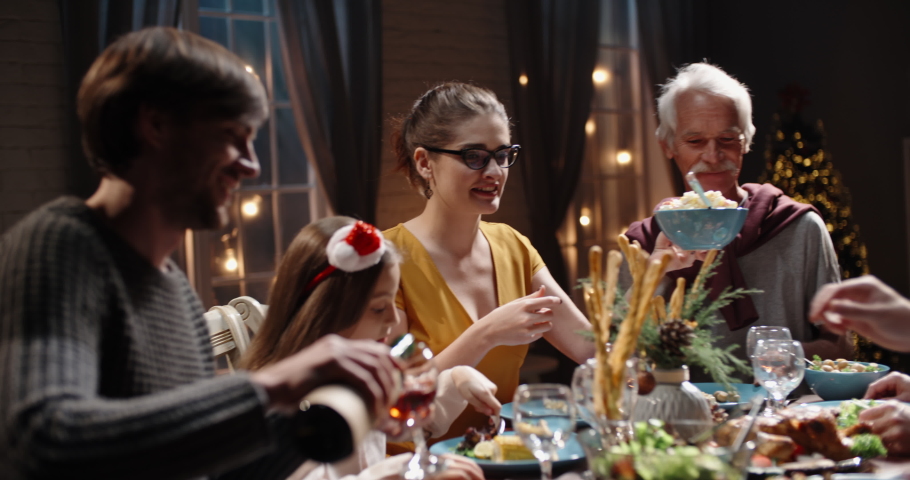 Happy large caucasian family of different generations celebrating christmas at home. People having a dinner xmas party eating, talking and smiling 4k footage | Shutterstock HD Video #1058343694