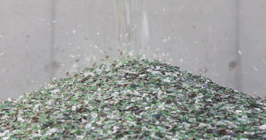Details with shards of glass falling from a conveyor belt on a pile in a glass recycling facility. Royalty-Free Stock Footage #1058346472