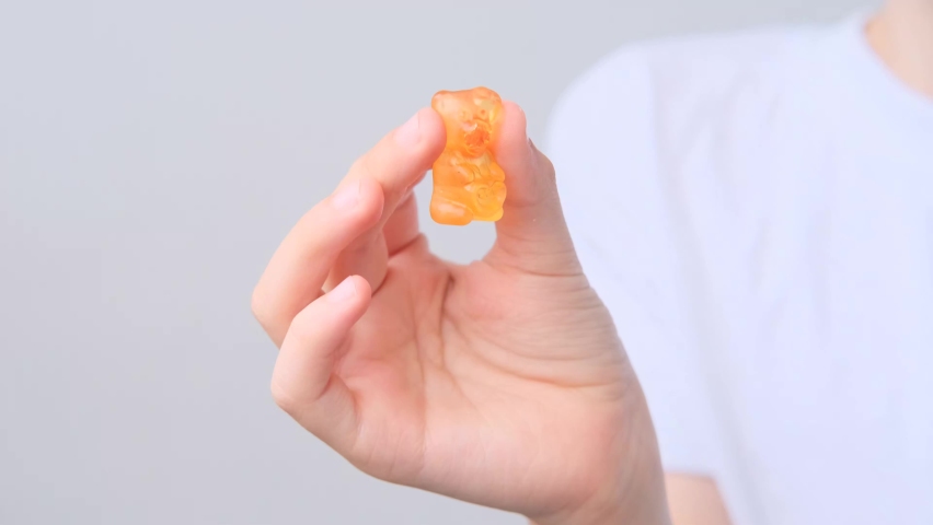 boy, kid holds in his mouth and eats gelatinous sweets, gummy bear, concept of children's delicacy, healthy and unhealthy food, halal food Royalty-Free Stock Footage #1058351944