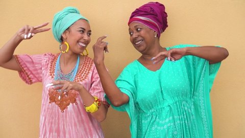 Happy mother and daughter with traditional african dancing together - Family lifestyle and ethnic concept - Slow Motion