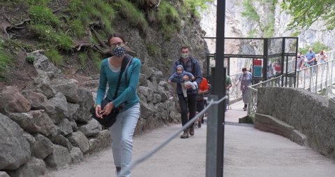 Bavaria, Germany - August 22, 2020: Tourist wearing medical masks visit the famous pedestrian Marienbrucke bridge at Neuschwanstein castle, in small groups, following restrictions for Coronavirus.