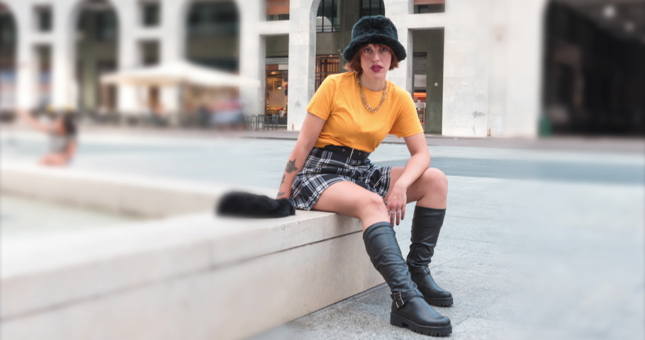 Beautiful girl dressed in fashion is posing. European old town square. People walking. 4K VIdeo Time Lapse