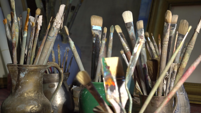 Artist's art tools in the Studio. Oil paintings in creative workroom. Brushes, paints, palette, canvas, easel Royalty-Free Stock Footage #1058364334