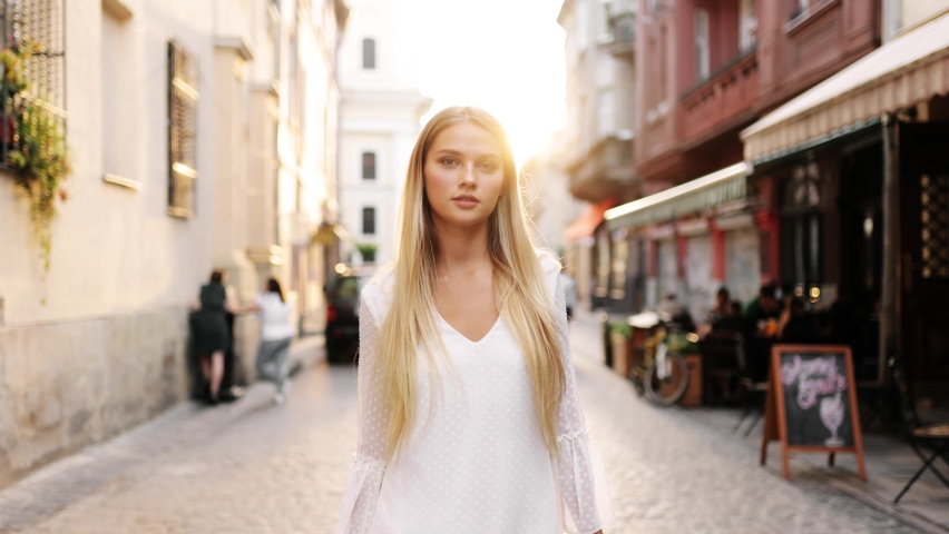 Portrait young attractive smile woman look at camera at city center. Outdoor portrait happy female tourist having good time wandering around town in summer. | Shutterstock HD Video #1058366314