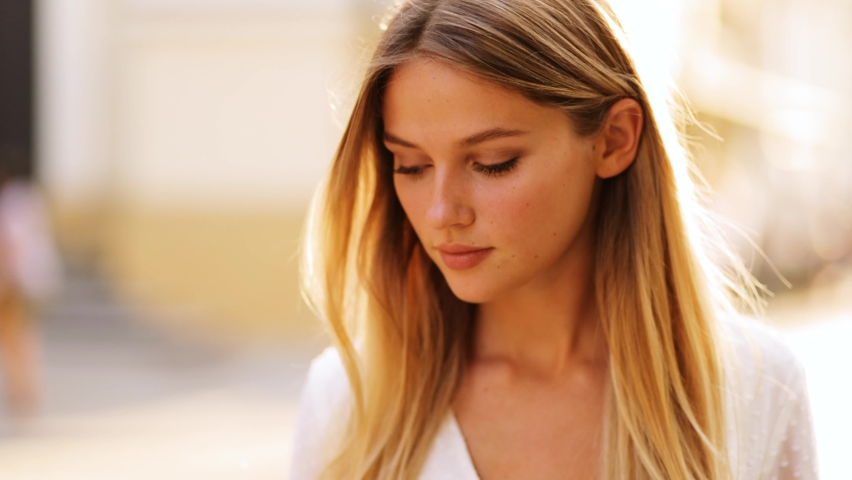 Closeup face of beautiful blond sexy smiling woman with long hair. Portrait of gorgeous girl looking to camera