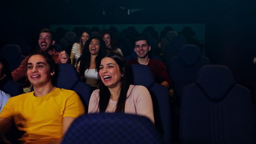 Group of cheerful people laughing while watching movie in cinema. Royalty-Free Stock Footage #1058371813