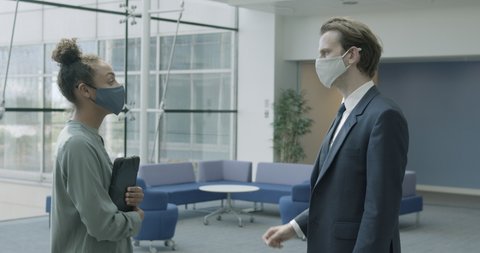 Business people office meeting in lobby wearing protective face mask and using digital tablet