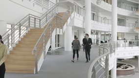 Business people wearing face mask walking and meeting in modern corporate office lobby during Coronavirus pandemic - Powered by Shutterstock - Get 15% off with code: PIKWIZARD15