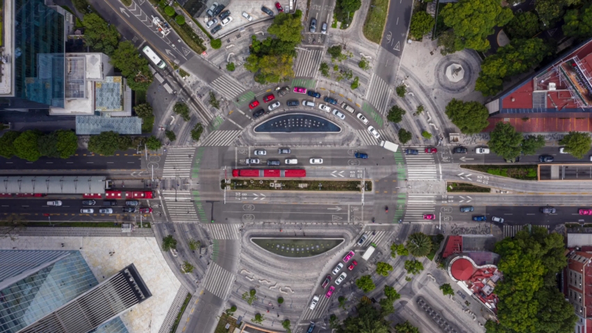 Aerial Hyperlapse view above traffic at a roundabout, on a sunny day, in Mexico city, America - Top down, time lapse, drone shot