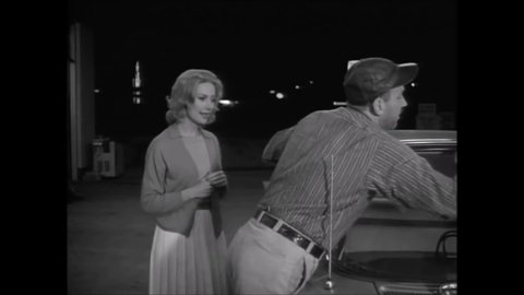 CIRCA 1962 - In this classic horror film, a woman gets her car filled up at a gas station at night and asks the attendant for directions.