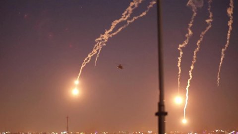 CIRCA 2019 U.S. Army AH-64 Apache Helicopters drop flares near the US Embassy as a deterrence against protestors, Baghdad, Iraq.