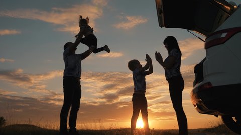 Happy family travel by car.Family picnic in park with car.Parents child play in park in grass.Happy family concept.Freedom on vacation. Active travel by car. Silhouette of group of people at sunset
