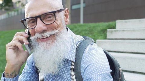 
Hipster senior lifestyle moments. Handsome man with long beard spending time in downtown