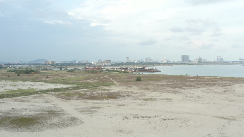 Drone view flying above sandy beach with trees. 