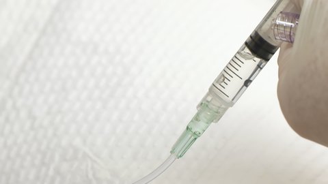 Close-up of Doctor Flushing IV in Young Patient with Saline