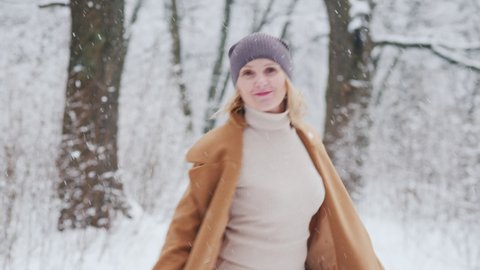 Happy woman enjoys a walk in winter park วิดีโอสต็อก