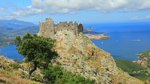 Iconic view of Volterraio Castle on rock at 394 m. Fortress of Volterraio, symbol of Elba Island, dominates Portoferraio Gulf. Panoramic landscape with view from top of Elba mountain. Tuscany, Italy.