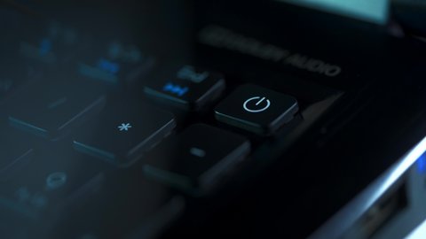 FINGER PULSATING POWER BUTTON ON A NOTEBOOK KEYPAD AND TURNING IN WITH LIGHTS