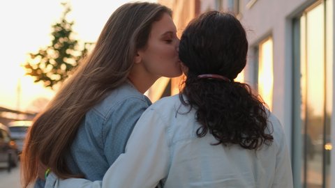 Two lesbian woman lgbt couple girlfriends hugging, kissing, hands with rainbow symbol. Gay, bisexual, transgender movements. Concept of LGBT happiness, freedom, love same-sex couple, 4 K slow-mo
