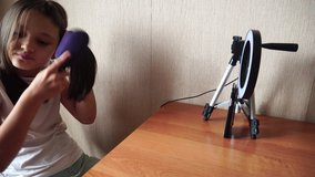 girl combing her hair before shooting a video