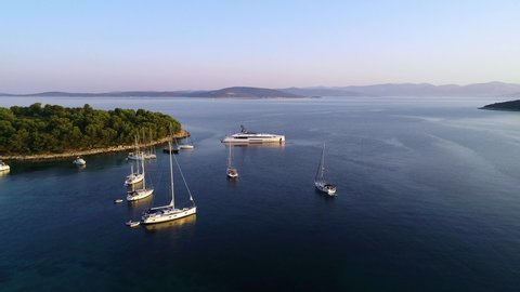 Aerial view of white luxury yachts and sailboats embarked in bay in  Croatia, France, Greece, Ibiza, Italy,Europe. Summer season sailing experience during yacht week.