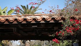 Mexican colonial style suburban, hispanic house exterior, green lush garden, San Diego, California USA. Mediterranean terracotta ceramic clay tile on roof. Rustic spanish tiled rooftop. Rural details.