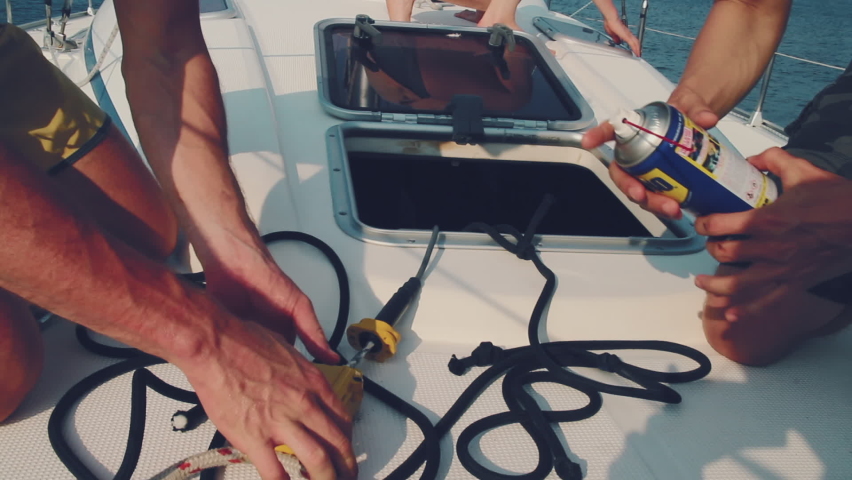 Men fix the boat. Two young men fix broken device on the sailboat