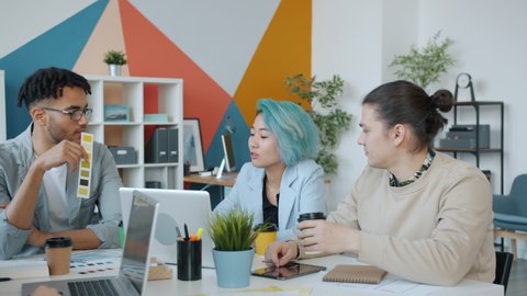 Joyful designers colleagues are talking drinking take away coffee and laughing in workplace during lively business discussion in creative office Stock Video