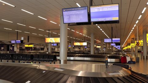 Amsterdam , Noord-Holland / Netherlands - 07 22 2020: Baggage claim conveyor belt passing by very few luggages in almost deserted international airport during the COVID-19 virus outbreak