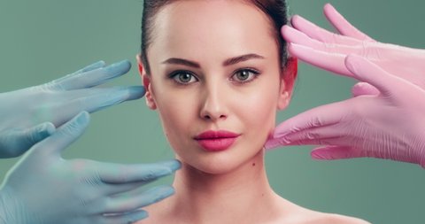 Slow motion clip - Doctor checks a skin before plastic surgery.  Face skin check before plastic surgery. Beautician touching woman face. Plastic surgery. Doctor is touching face of a patient by hands