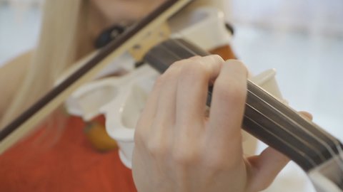 Close up hands of unrecognizable woman performing classic music on violin. Girl is practicing playing musical instrument. Lady composing new melody. Slow motion