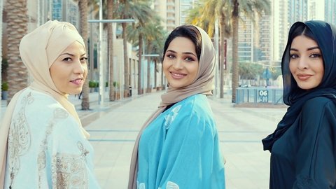 
Three friends making shopping and spending time together in Dubai. Group of women wearing traditional uae abaya clothes outdoor