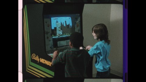1980 United States. Two Boy's play Rampage the Vintage Arcade Game. 4K Overscan of Archival 16mm Film with Edge Lines and Sprocket Holes