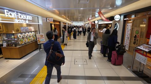 TOKYO - APRIL 06, 2018: Unidentified people walk along passage, dining area at basement floor of Tokyo Station. Wide angle shot, camera move forward. Many restaurants and cafes at Nippon Gourmet Road