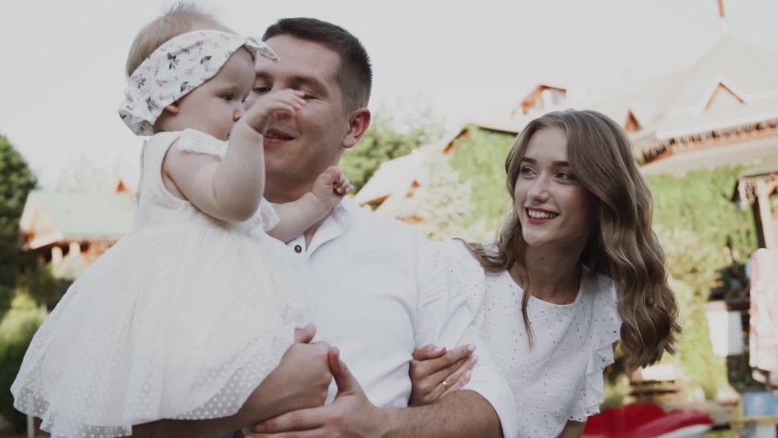 Happy Young Family with child walking on summer park.The concept of a happy family and family values. slow motion