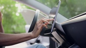 Side view of unrecognizable black-skinned man which typing needed coordinates on navigator touchscreen while speaking on smartphone inside his auto - Powered by Shutterstock - Get 15% off with code: PIKWIZARD15