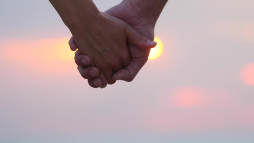 Two lovers with separated hands. A sign of love, close relationships, divorce. Man and woman holding hands, then part against the sky. Couple gesturing concept of ending relationship between them Royalty-Free Stock Footage #1058446519